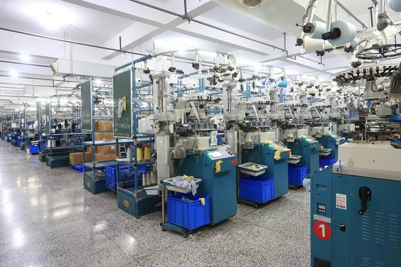 Factory worker checking custom sock production details